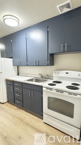 A kitchen with a white stove top oven and a white refrigerator.