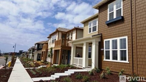 A row of houses with a sidewalk in front.