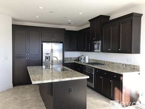 A kitchen with black cabinets and granite countertops.