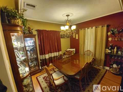 A dining room with a wooden table and chairs.