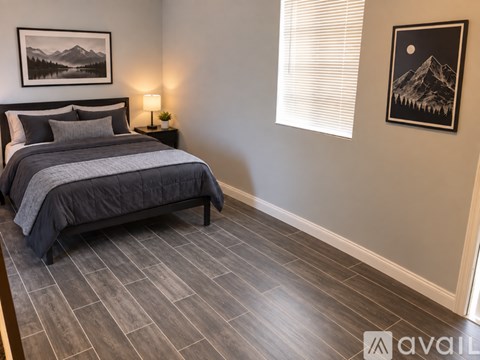A bedroom with a large bed and a painting on the wall.
