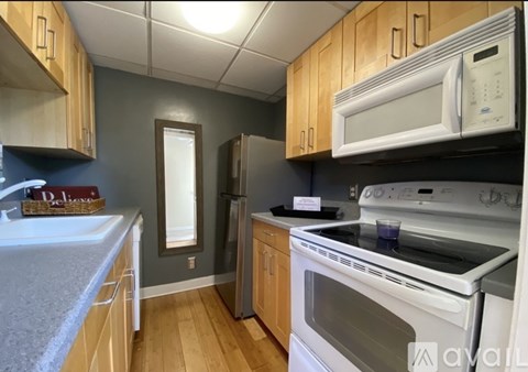 A kitchen with a white microwave above a stove and a white oven below it.