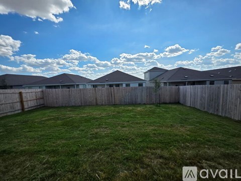 A backyard with a wooden fence and a grassy area.