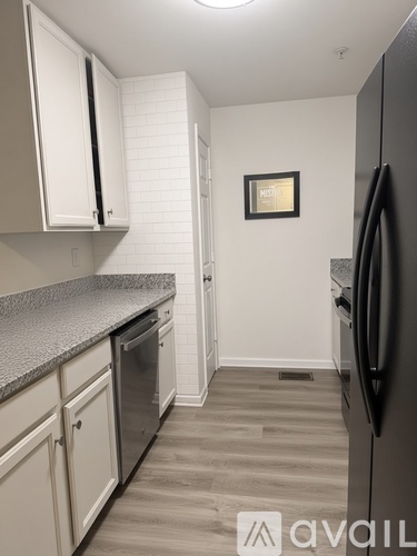 A kitchen with a fridge, cabinets and a dishwasher.