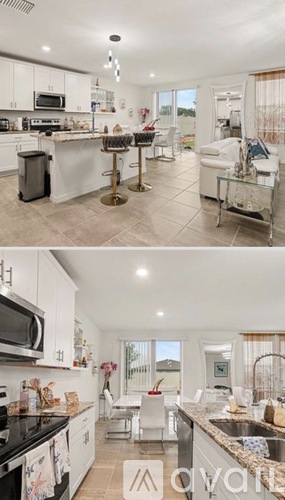 A modern kitchen with white cabinets and black countertops.