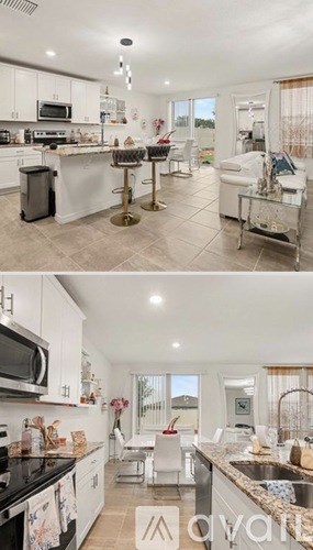 A modern kitchen with white cabinets and black countertops.