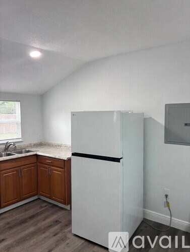 A kitchen with a white fridge and wooden cabinets.