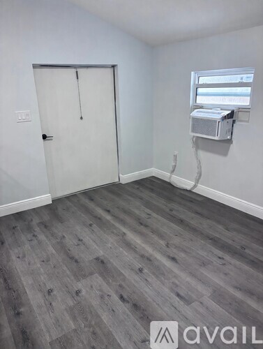 A room with a grey floor and a white door.