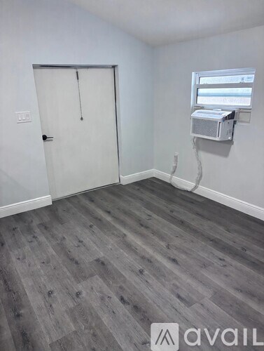 A room with a grey floor and a white door.