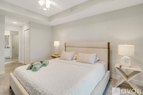 A bedroom with a large bed and a ceiling fan.