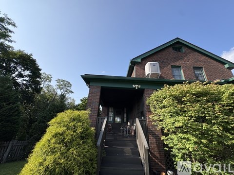 A house with a green roof and a staircase leading to the entrance.