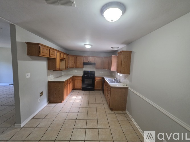 A kitchen with wooden cabinets and a black dishwasher.