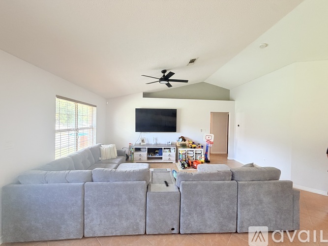 A living room with a grey sectional sofa and a television.