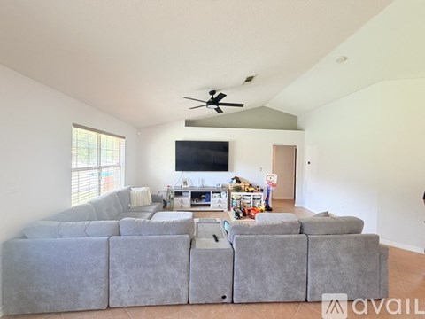 A living room with a grey sectional sofa and a television.