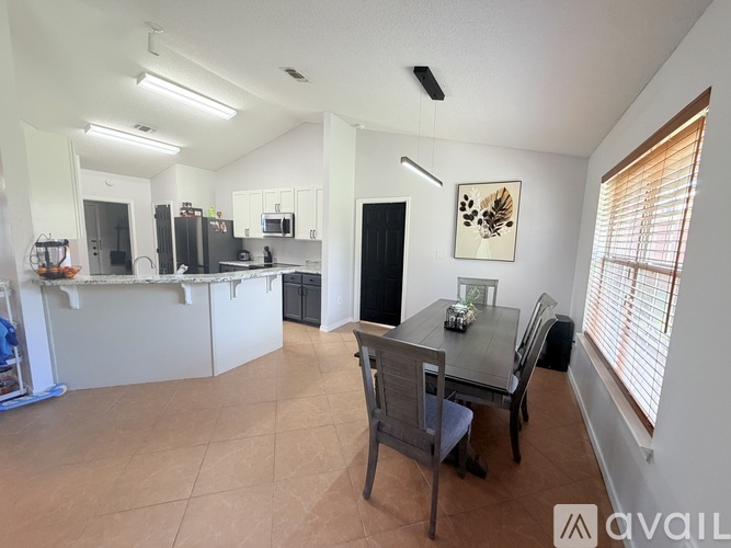 A kitchen with a dining table and chairs.