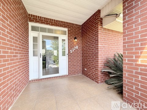 A red brick wall with a white door and a glass window.