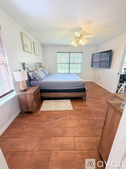 A bedroom with a bed, nightstand, and window.