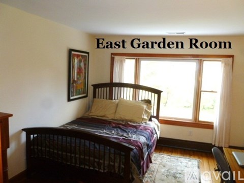A bedroom with a bed and a window.