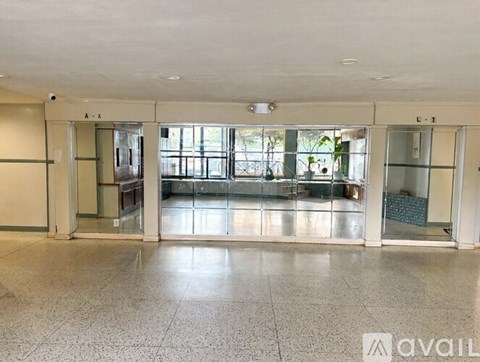 A spacious room with tiled flooring and glass doors leading to a balcony.
