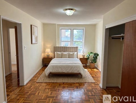 A bedroom with a large bed and a wooden floor.