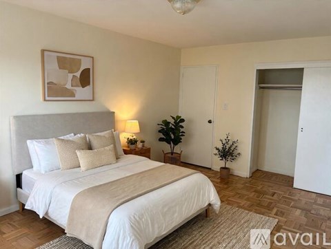 A bedroom with a large bed and a painting on the wall.