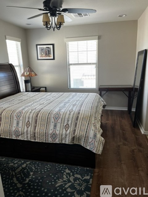 A bedroom with a large bed and a ceiling fan.