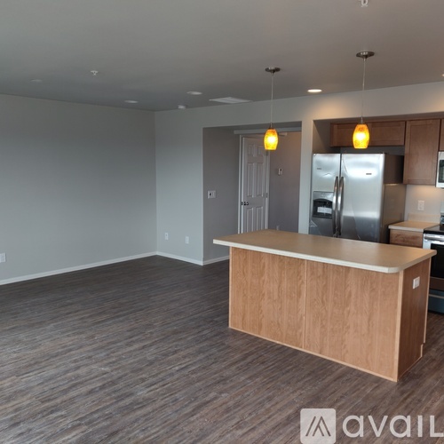 A kitchen area with a wooden counter and a refrigerator.