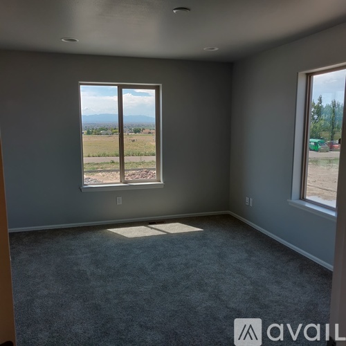 A room with a large window overlooking a landscape.