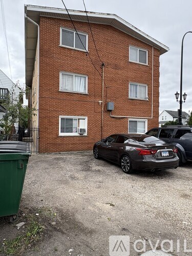 A car is parked in front of a red brick building.