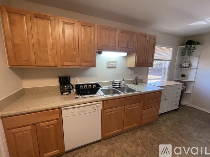 A kitchen with wooden cabinets and a white dishwasher.