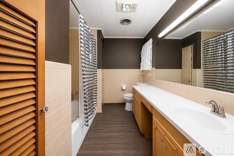 A bathroom with a toilet, sink, and mirror.