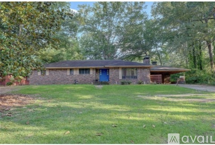 A house with a blue door is surrounded by trees.