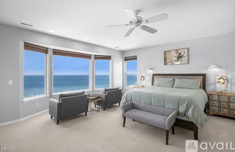 A bedroom with a large bed and a view of the ocean.