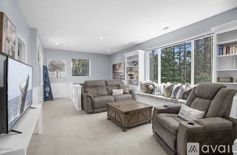 A living room with a grey sofa and a television on the left side.