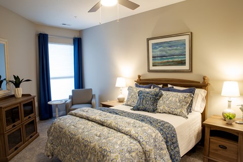 A bedroom with a large bed and a painting on the wall.