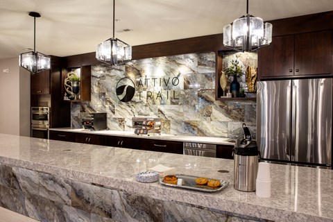 A kitchen counter with a tray of donuts and a coffee maker.