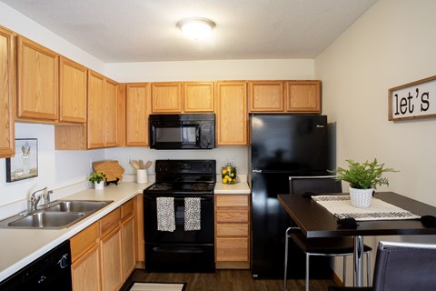 A kitchen with wooden cabinets and black appliances.
