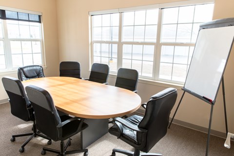 A conference room with a whiteboard and six chairs.