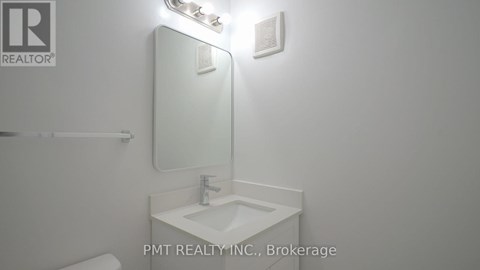 A bathroom with a sink, mirror, and light fixture.