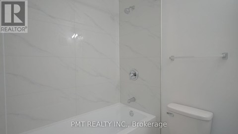A bathroom with a toilet, shower, and a glass door.