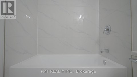 A white bathroom with a marble tile shower.
