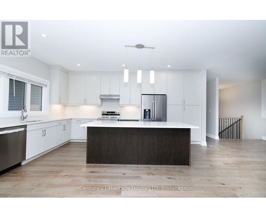 A modern kitchen with white cabinets and a wooden island.