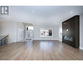 A spacious living room with a fireplace and a view of the backyard.