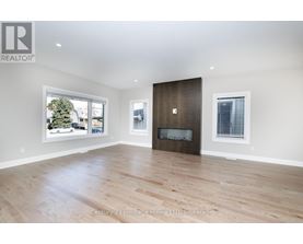 A spacious room with a fireplace and a large window.