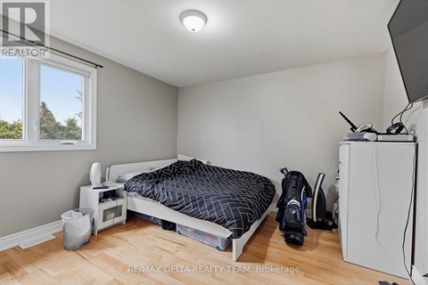 A bedroom with a bed, a microwave, a fridge, and a window.