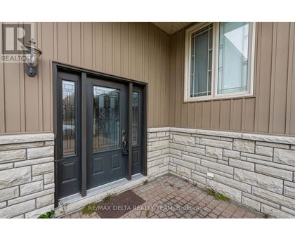 A house entrance with a black door and a window above it.