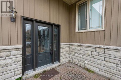 A house entrance with a black door and a window above it.