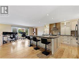 A well-lit kitchen with a dining table and chairs.