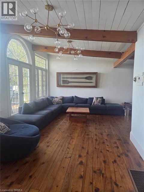 A living room with a blue couch and a wooden floor.