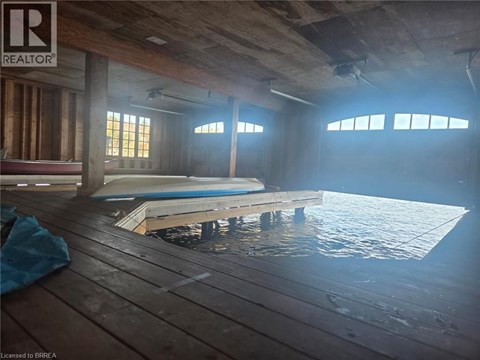 A room with a pool table and wooden floors.